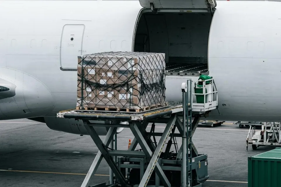 Illustration of netted cargo pallets being loaded into a freight aircraft